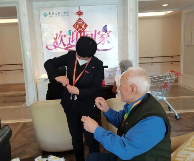 　　泰康健投优秀党员、泰康之家·申园总经理肖欣慧帮助长辈做抗原检测