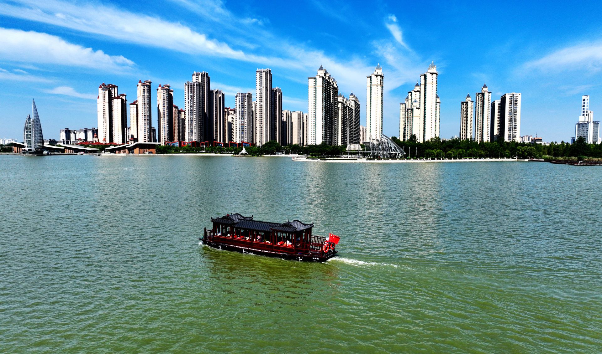 满载游客的游船在风光秀美的龙子湖上航行