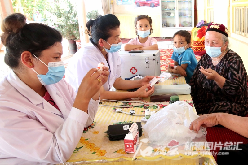 伽师县江巴孜乡托万尕勒村卫生室的村医，在村民吾布力·阿布拉家给村民讲解吃药注意事项。记者 蔡增乐摄
