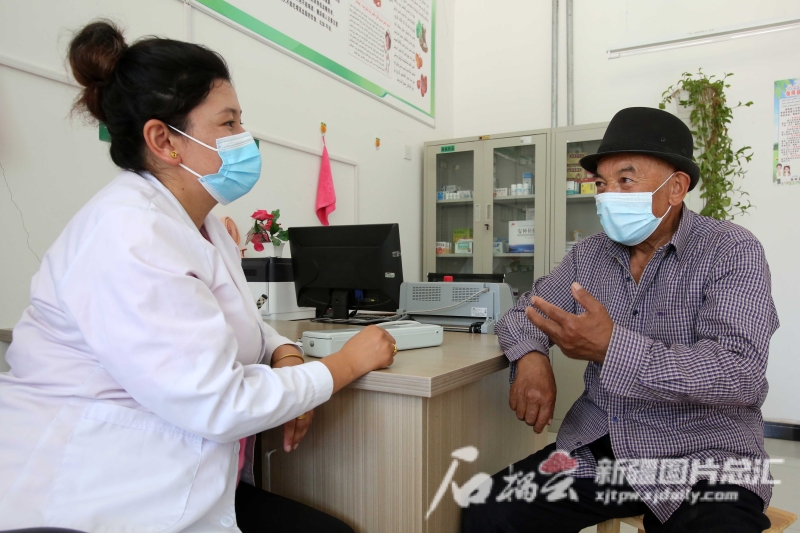 在伽师县江巴孜乡托万尕勒村卫生室，村医古哈尔尼沙·吐尔洪为村民看诊。记者 蔡增乐摄