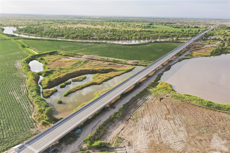 尉犁至且末沙漠公路穿越塔里木河和胡杨林（6月22日摄，无人机照片）。新华社记者 李响 摄
