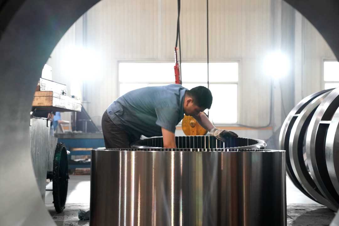 工人在河北汇工机械设备有限公司生产车间内准备吊装齿圈.赵一静摄