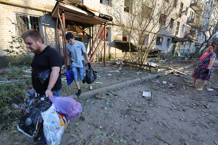 6月20日，顿涅茨克当地居民从被损坏的建筑撤离。新华社发（维克托摄）