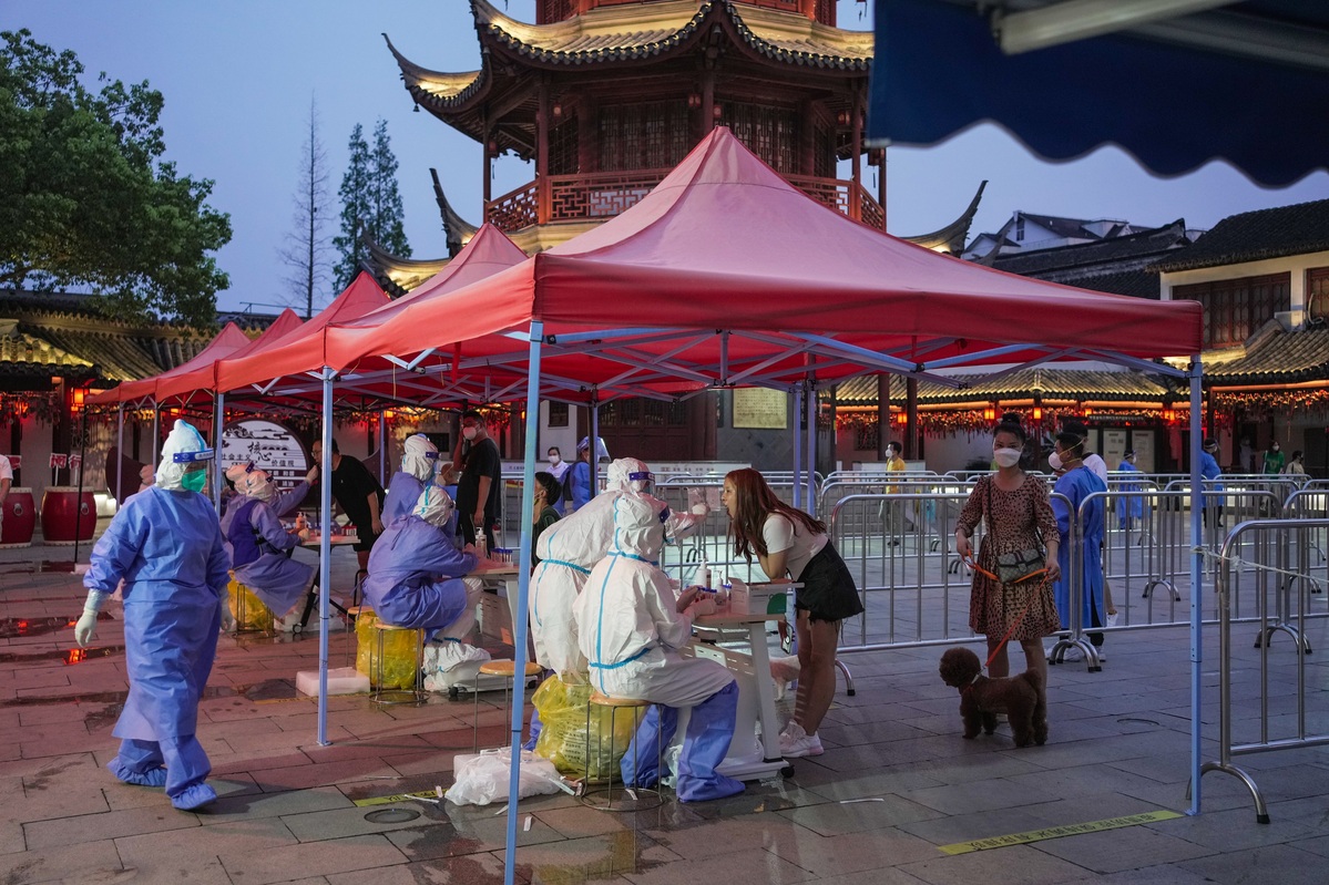 7月12日，市民在上海市闵行区七宝古镇广场上的核酸检测采样处进行采样。（中国日报记者 高尔强 摄）