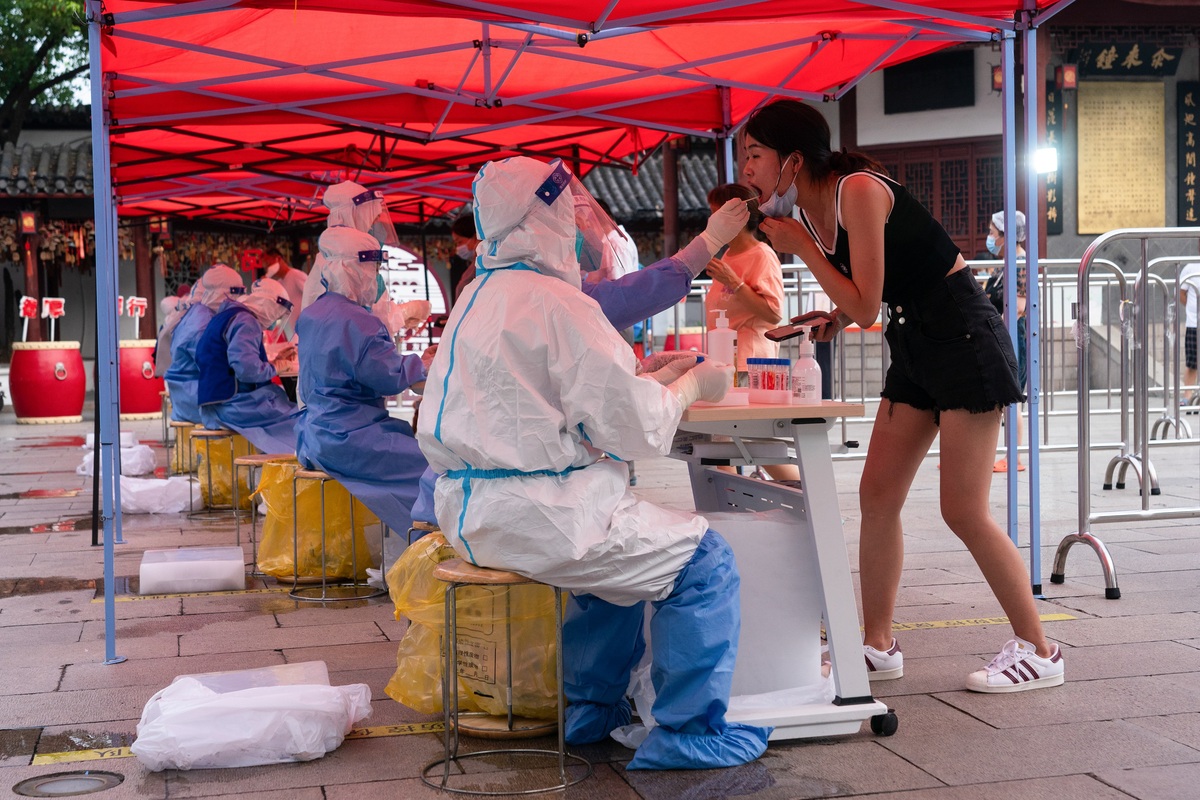 7月12日，市民在上海市闵行区七宝古镇广场上的核酸检测采样处进行采样。（中国日报记者 高尔强 摄）