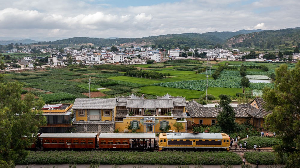  7月1日，游客乘坐建水米轨小火车来到乡会桥站游览（无人机照片）。新华社记者胡超摄
