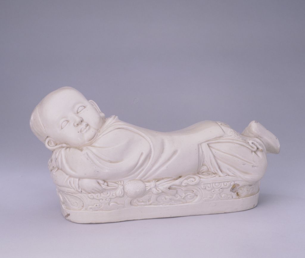 定窑白釉孩儿枕，宋，高18.3厘米，长30厘米，宽18.3厘米。 图源：故宫博物院