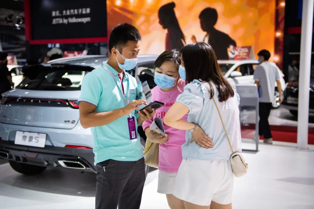 　　2022年7月13日，2022湖南汽车展览会暨长沙市汽车消费节在位于长沙的湖南国际会展中心举行。在湖南国际会展中心，工作人员（左一）向观众介绍产品。  新华社记者 陈思汗 摄