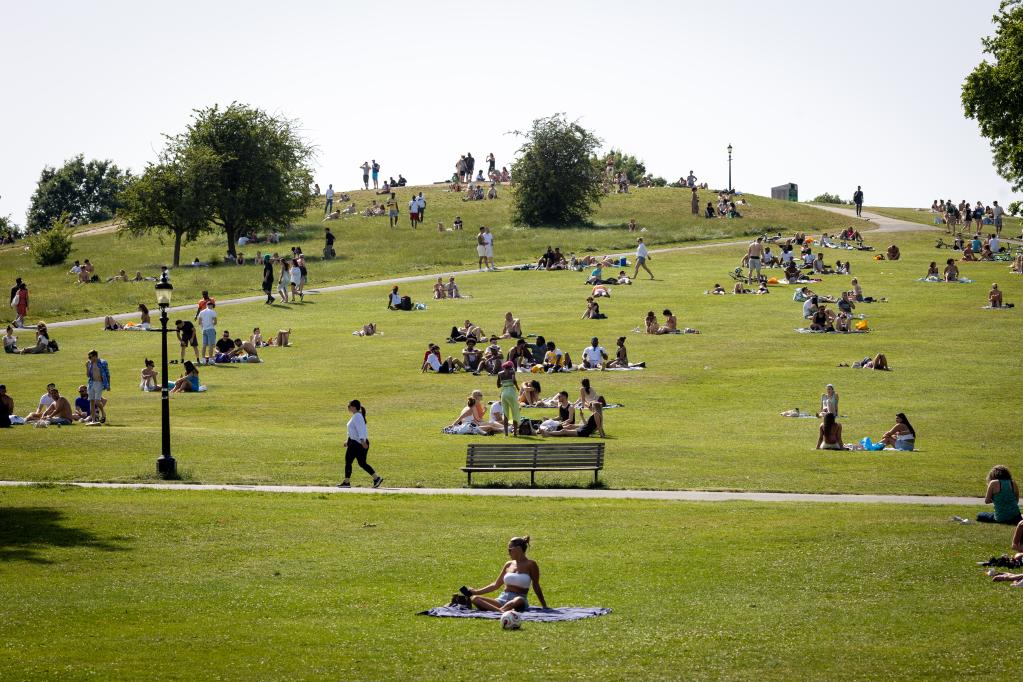 2022年6月17日，人们在英国伦敦一处山坡上享受阳光。（新华社发）