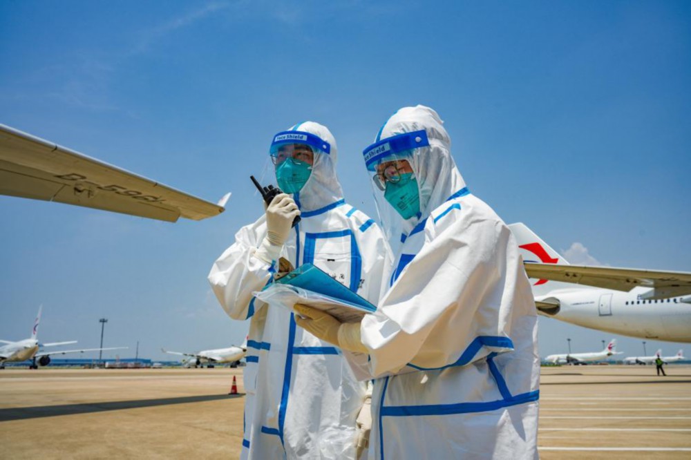 7月7日，浦东国际机场海关关员在停机坪查验登记，严防疫情输入。新华社发（受访对象供图）