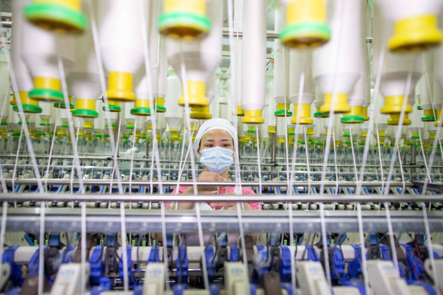 7月15日，江苏省海安市一家纺织公司生产车间内，工人在生产线上工作。新华社发（翟慧勇摄）
