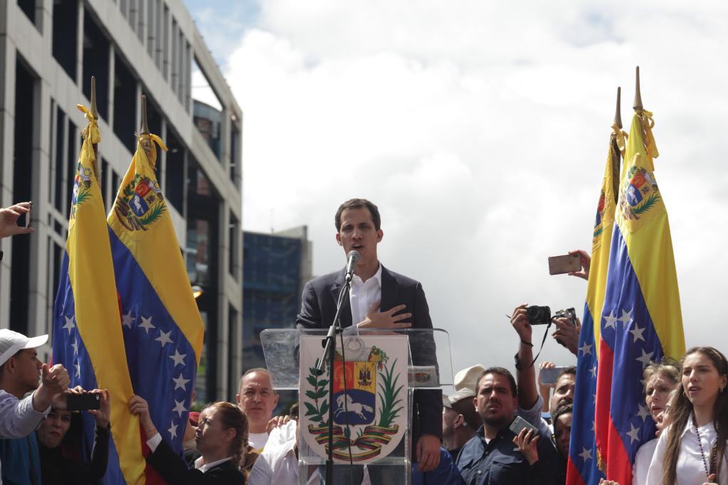 2019年1月23日，委内瑞拉反对党成员胡安·瓜伊多（中）在支持者集会上发表讲话。新华社发（鲍里斯·贝尔加拉摄）