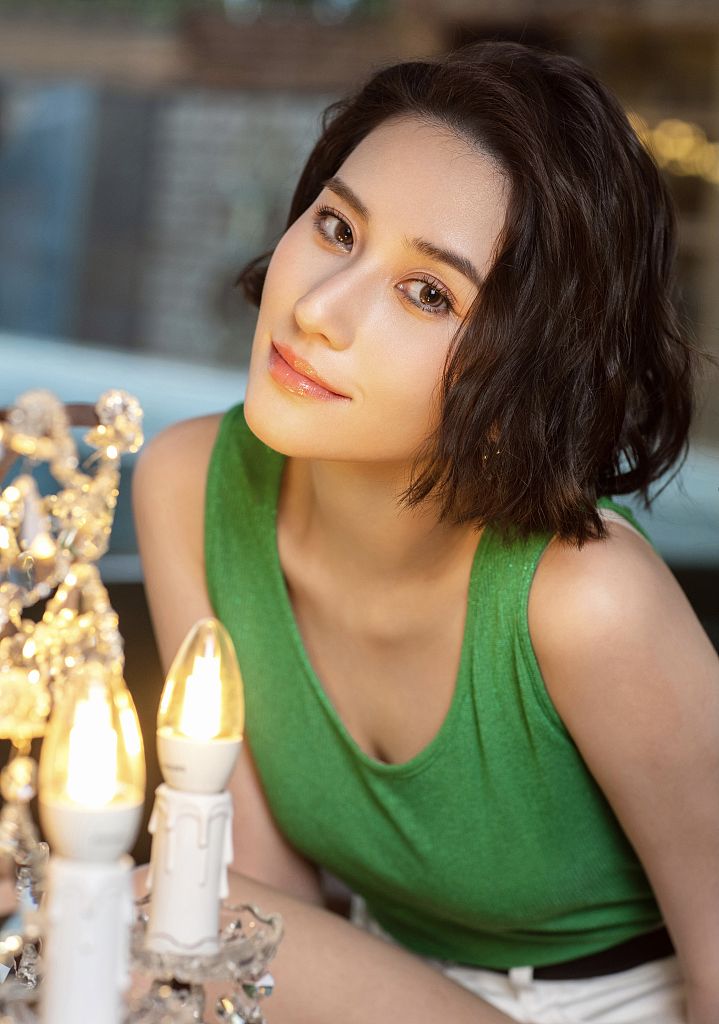 何超莲发布一组港风写真穿绿色背心微卷短发造型复古