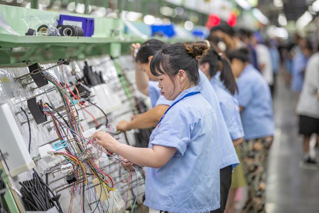 7月19日,在重庆长秦汽车配件有限公司,工作人员在后工序车间进行线束