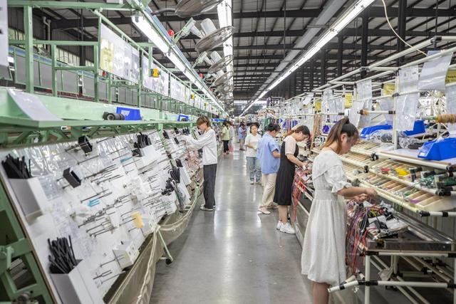 7月19日,重庆长秦汽车配件有限公司的工作人员在后工序车间进行线束