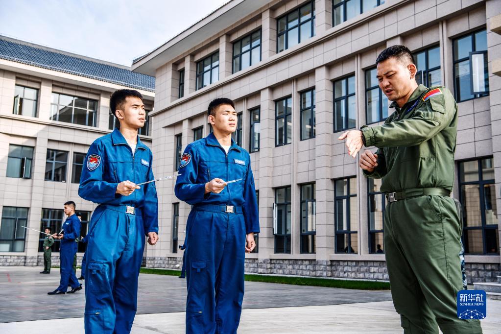 空军首批歼-10飞行学员在石家庄飞行学院某旅演练场与教官进行地面