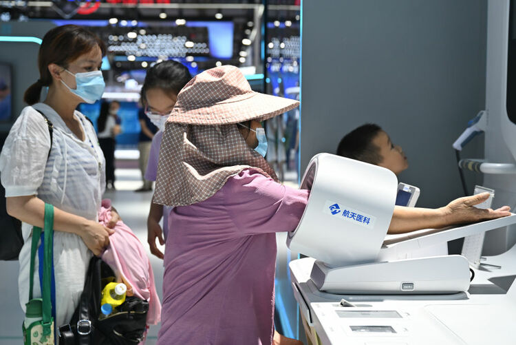 ↑7月22日，观众在第五届数字中国建设成果展览会上体验智慧医疗项目。新华社记者 周义 摄