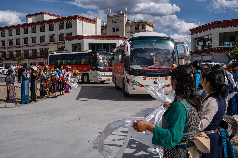 在森布日安置点,西藏山南市贡嘎县的群众欢迎远道而来的搬迁群众(7月