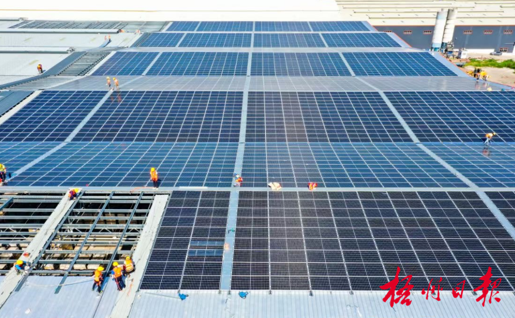 广西新舵陶瓷厂区厂房屋顶上,工人们忙着安装光伏发电组件.何华文 摄