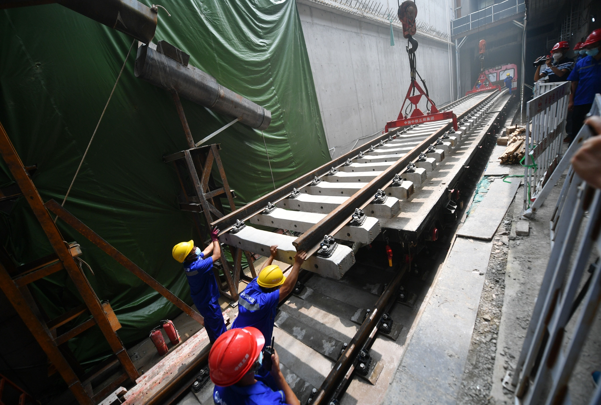 北京地铁12号线北岗子铺轨基地内,施工人员正在对轨排进行吊装.