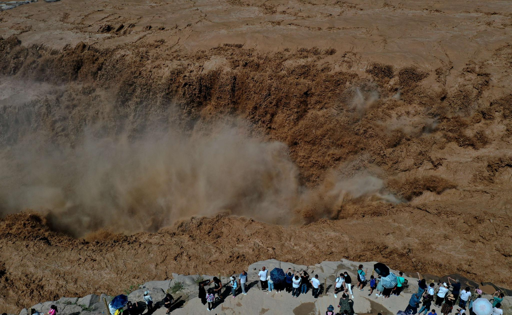 7月28日,游客在山西吉县黄河壶口瀑布景区游览观瀑。(吕桂明 摄)