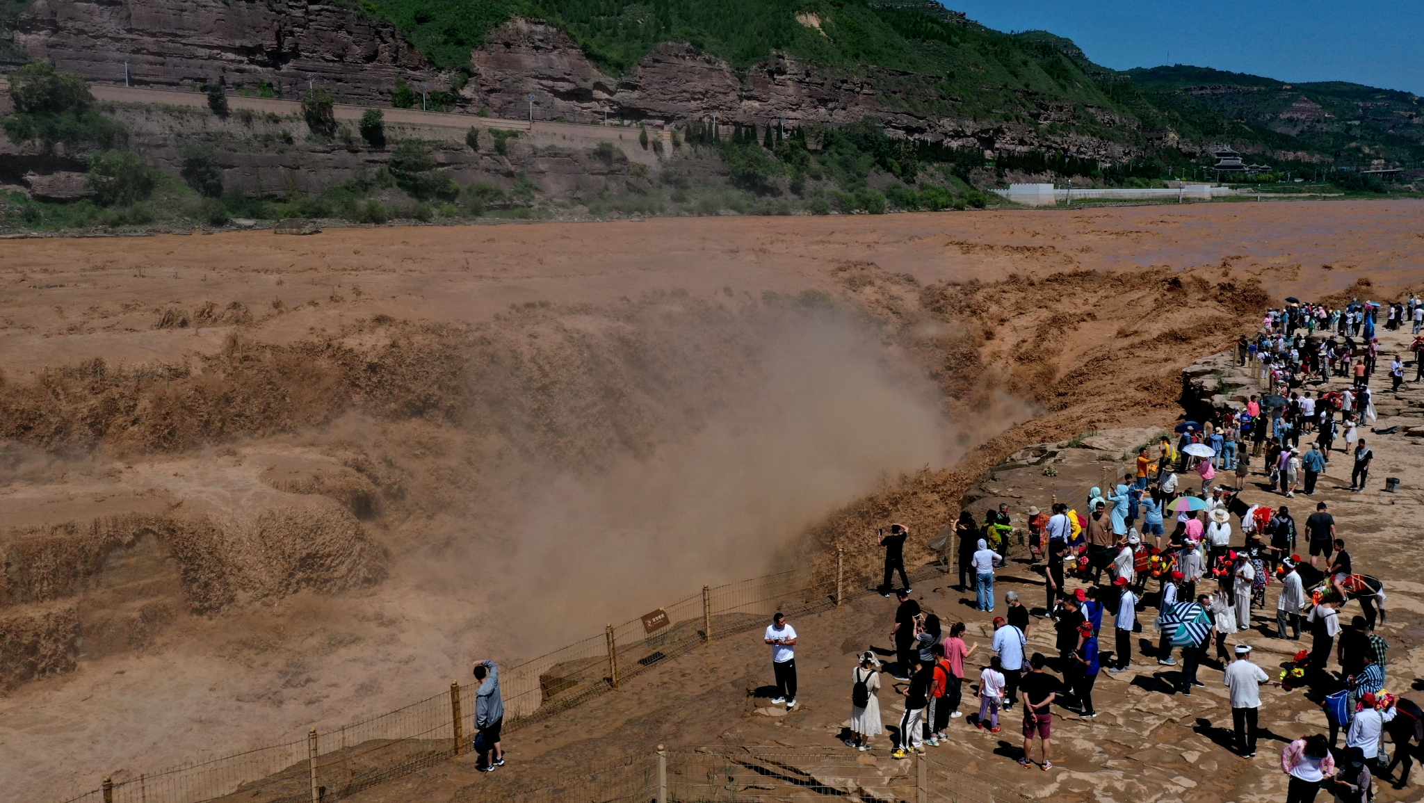 7月28日，游客在山西吉县黄河壶口瀑布景区游览观瀑。（吕桂明 摄）