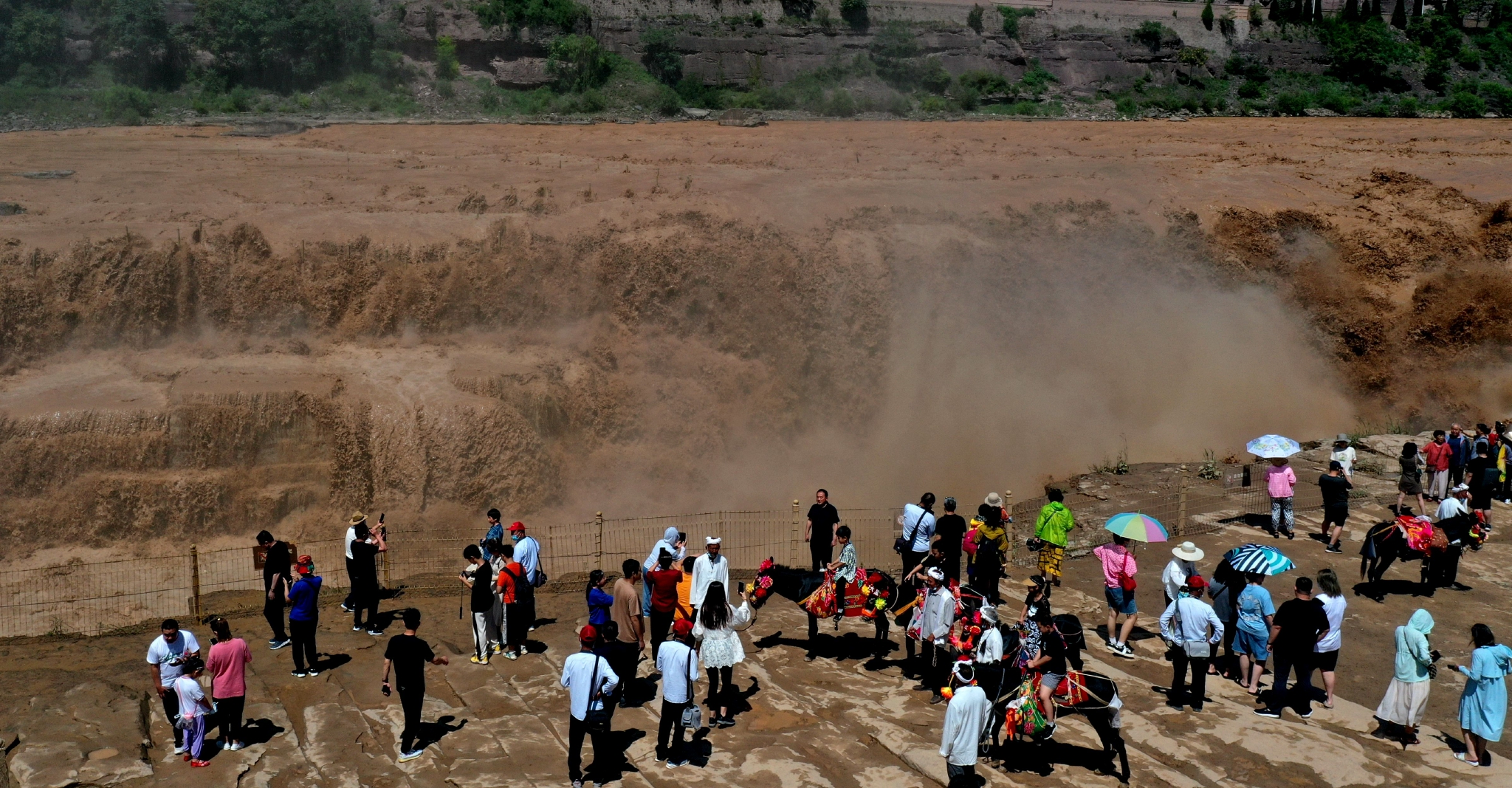 7月28日,游客在山西吉县黄河壶口瀑布景区游览观瀑。(吕桂明 摄)