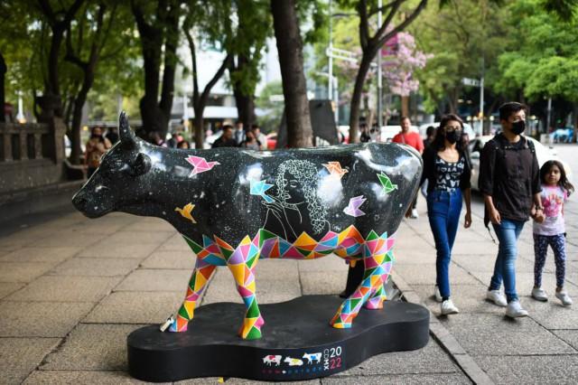 7月24日，在墨西哥首都墨西哥城改革大道，人們走過一件藝術牛作品。 （新華社記者辛悅衛 攝）