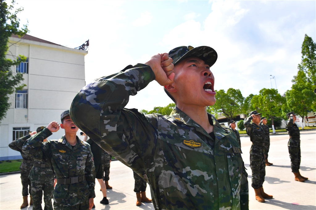 营区操场上,官兵身着新配发的21式夏季迷彩作训服,军容严整,军姿挺拔