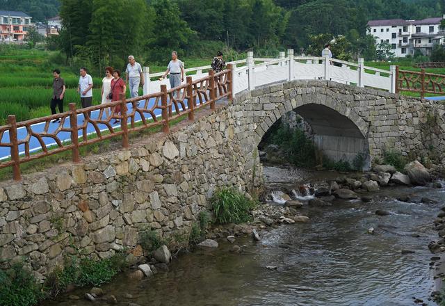 在江西省靖安县中源乡三坪村,"避暑住客"在小溪边散步(7月27日摄).