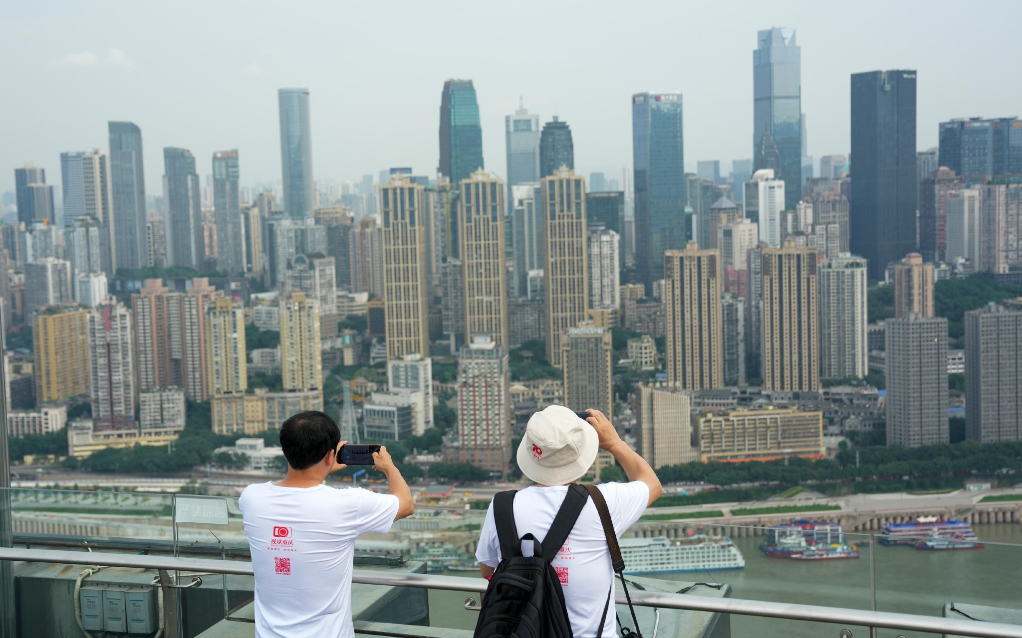 ▲市民在一栋高楼顶上拍摄城市景象。图/新华社