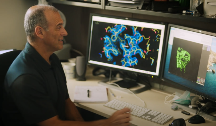 Marcelo Sousa 展示 AlphaFold 预测出的目标酶蛋白质结构 图片来源：DeepMind