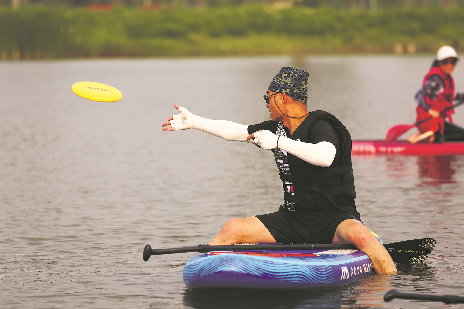 北京温榆河公园西园,桨板爱好者在桨板上玩飞盘 北京去野运动基地 供