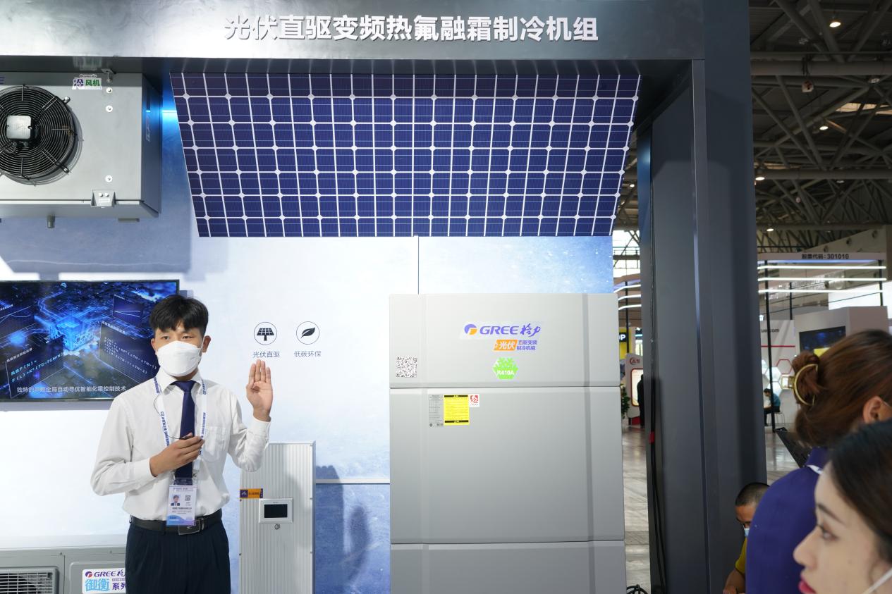 图为工作人员现场介绍格力光伏直驱变频热氟融霜制冷机组
