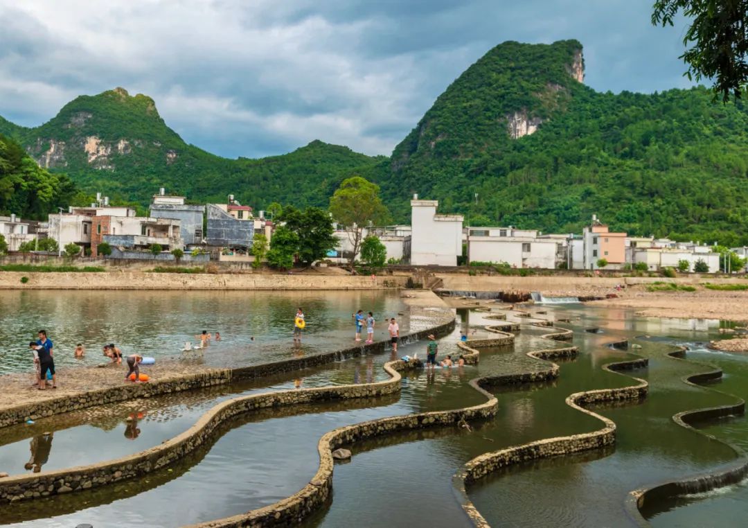 2022年8月4日,连州市连州镇水东村,村民在河中亲水平台玩耍.