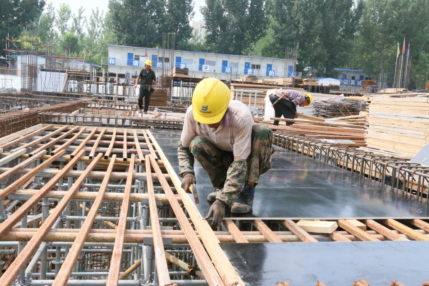 图为永清县林栖谷康旅中心项目建设现场,建筑工人正在固定浇筑模板.