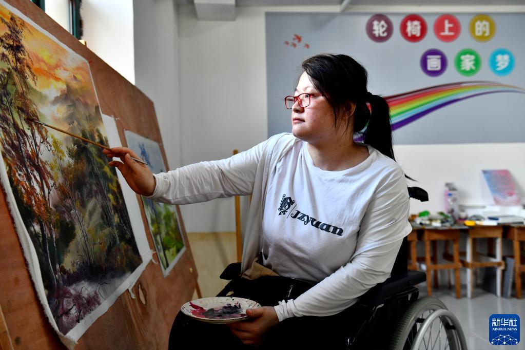 8月7日,在山东省威海市长城爱心大本营,残疾人学员在画画.
