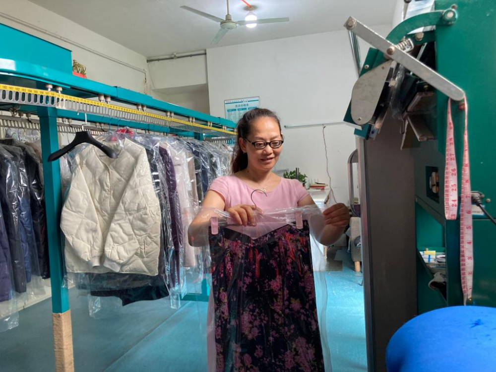 社区洗衣店负责人裴祥琼正在整理衣物。新华社记者 刘恩黎 摄