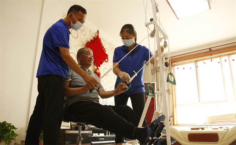 8月9日,邢台市襄都区医疗保障局居家护理服务人员协助老人进行康复