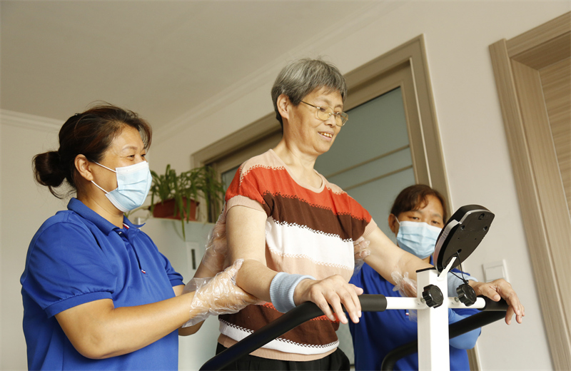 8月9日,邢台市襄都区医疗保障局居家护理服务人员协助老人进行康复