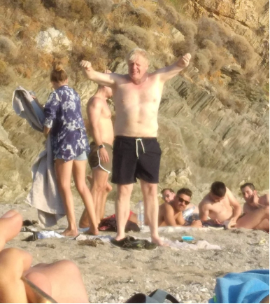 约翰逊被曝在希腊休假期间赤裸着上半身站在沙滩上，图源：英国《太阳报》