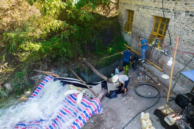 8月15日，在桃源县热市镇郭家垭村，乡镇水利站工作人员在取水点安装抽水设备(无人机照片)。新华社记者陈思汗 摄
