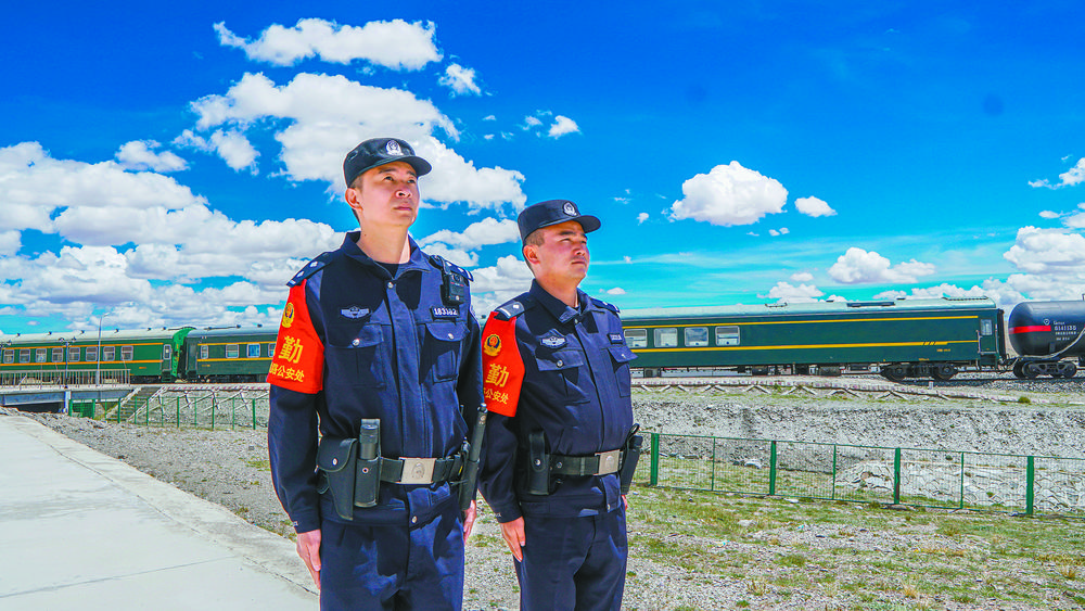 林胜（左一）与同事一起，在蓝天白云间守护“天路”安全。本报记者 张得俊 摄