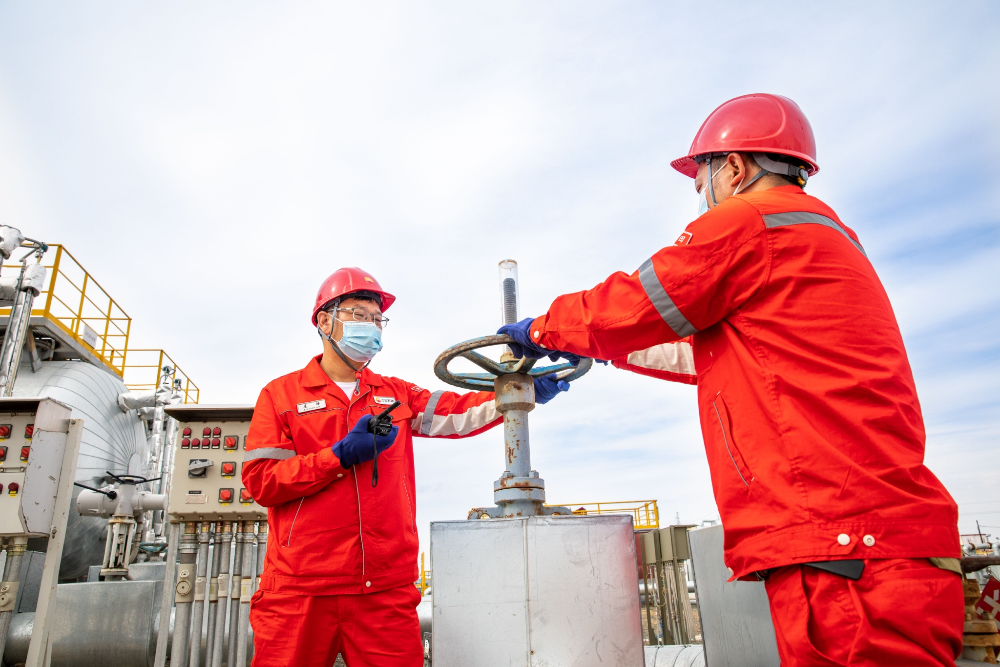 吉庆油田作业区吉祥联合站工作人员按中控室指令调整三项分离器阀门.