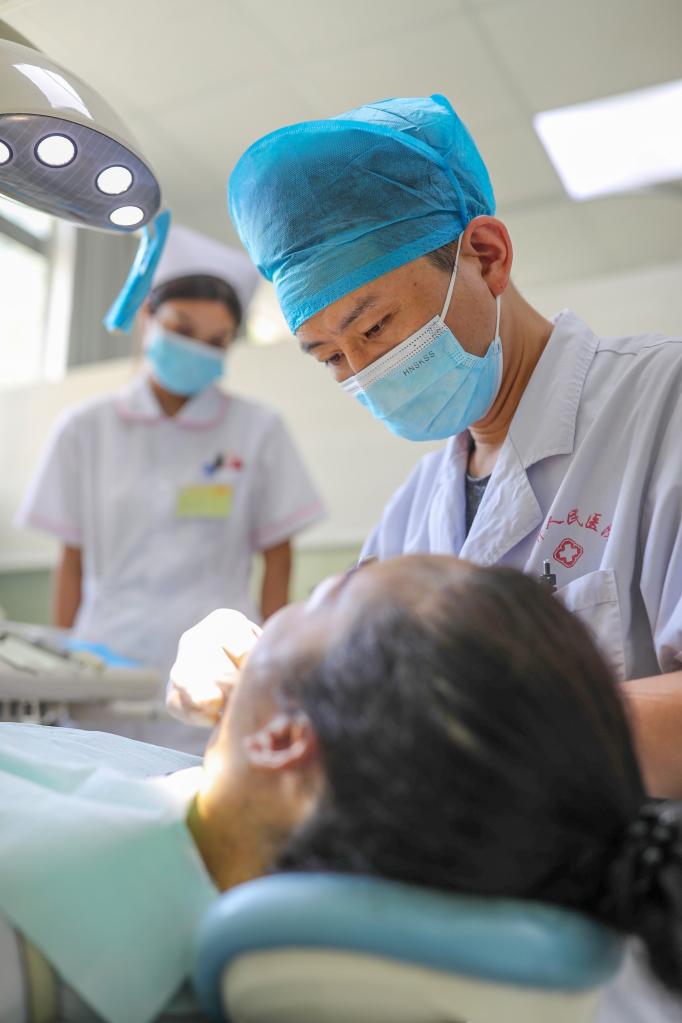 2022年8月18日，贵州省铜仁市玉屏侗族自治县人民医院口腔科医生在为牙病患者治疗。新华社发（胡攀学摄）