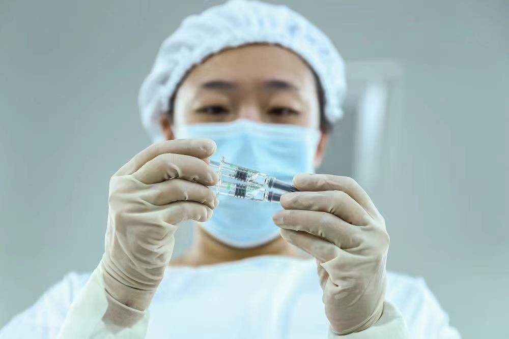 △2020年12月15日，一名工作人员在检查新冠病毒灭活疫苗产品的包装质量。