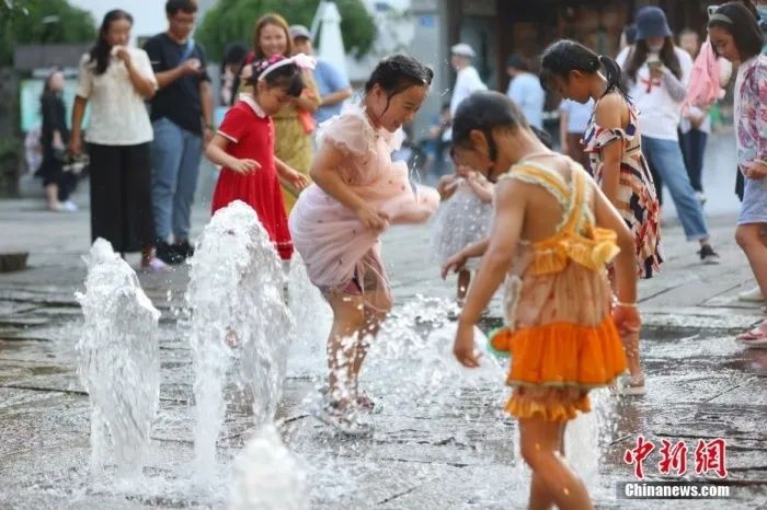 8月12日，江苏南京，小朋友在街头喷泉处戏水纳凉。当日，南京市气象台继续发布高温红色预警信号。图片来源：中新网