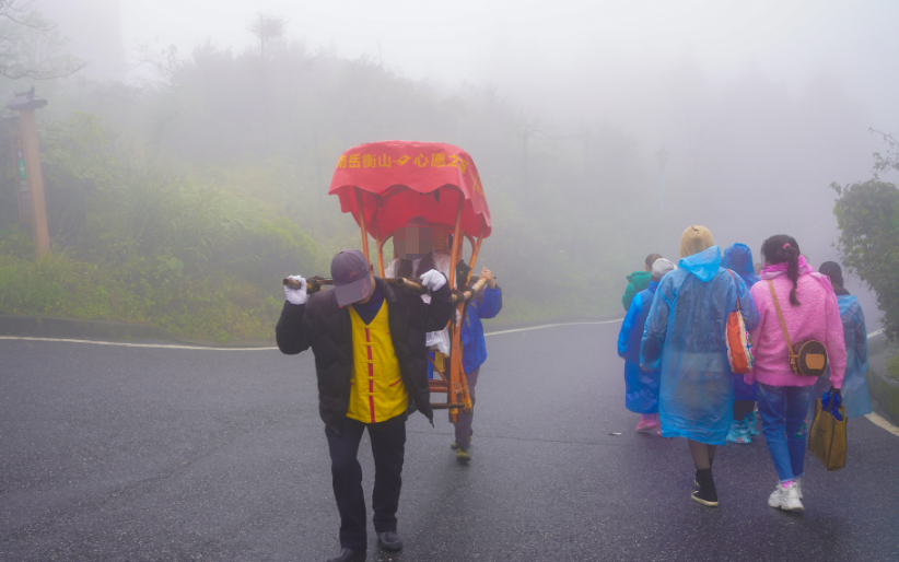 2021年10月17日,雨后的衡山雾气朦胧,游客体验坐轿子上山.