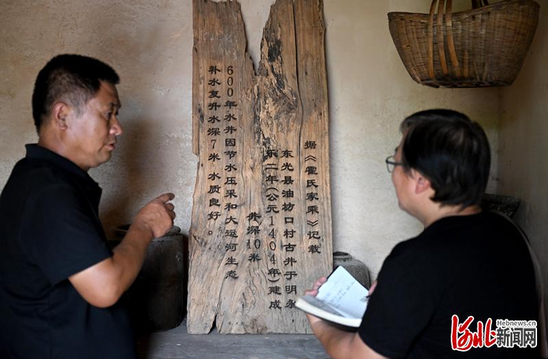 油坊口村村史馆内摆放着记载古井历史的木牌。