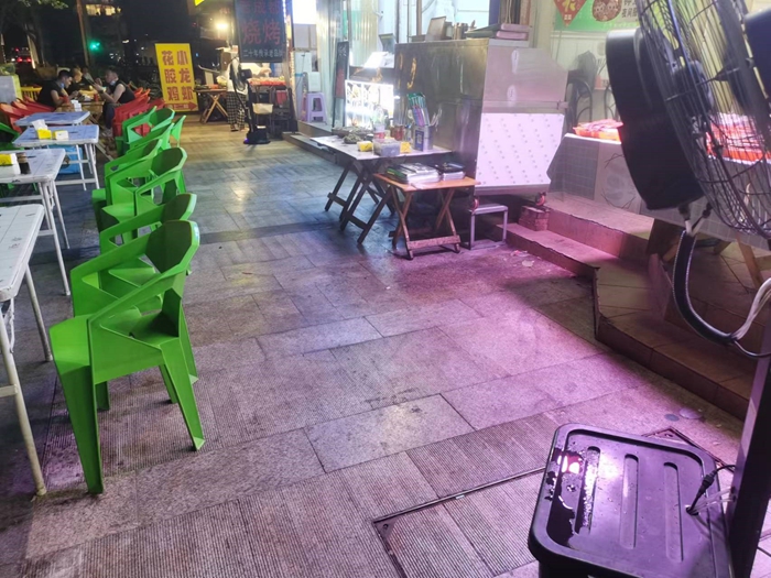店铺老板给风扇增加自制喷水装置。焦艳丽/摄